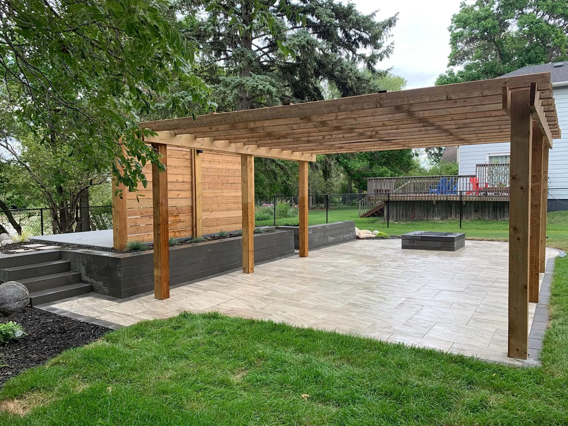 Cedar pergola over a paver patio with a charcoal block fire pit