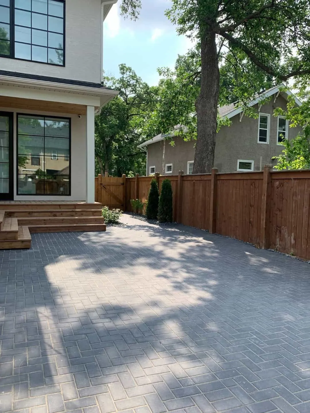 Planting beds and decorative rock along a paved side yard
