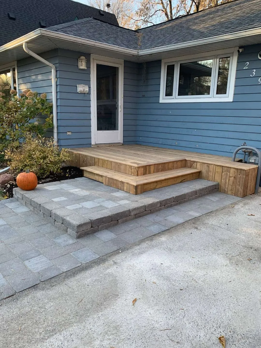 Cedar deck with a paver landing and steps at a front door